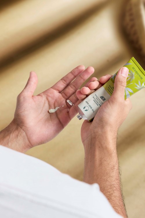 En person håller i en liten box med grönt och gult, möjligen en produkt eller medicin.