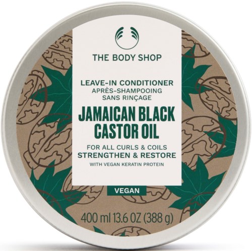 Ein kreisförmiges Etikett für The Body Shop Leave-In Conditioner mit jamaikanischem schwarzem Rizinusöl, vegan, für Locken, mit Pflanzen- und Rizinusplantenillustrationen.