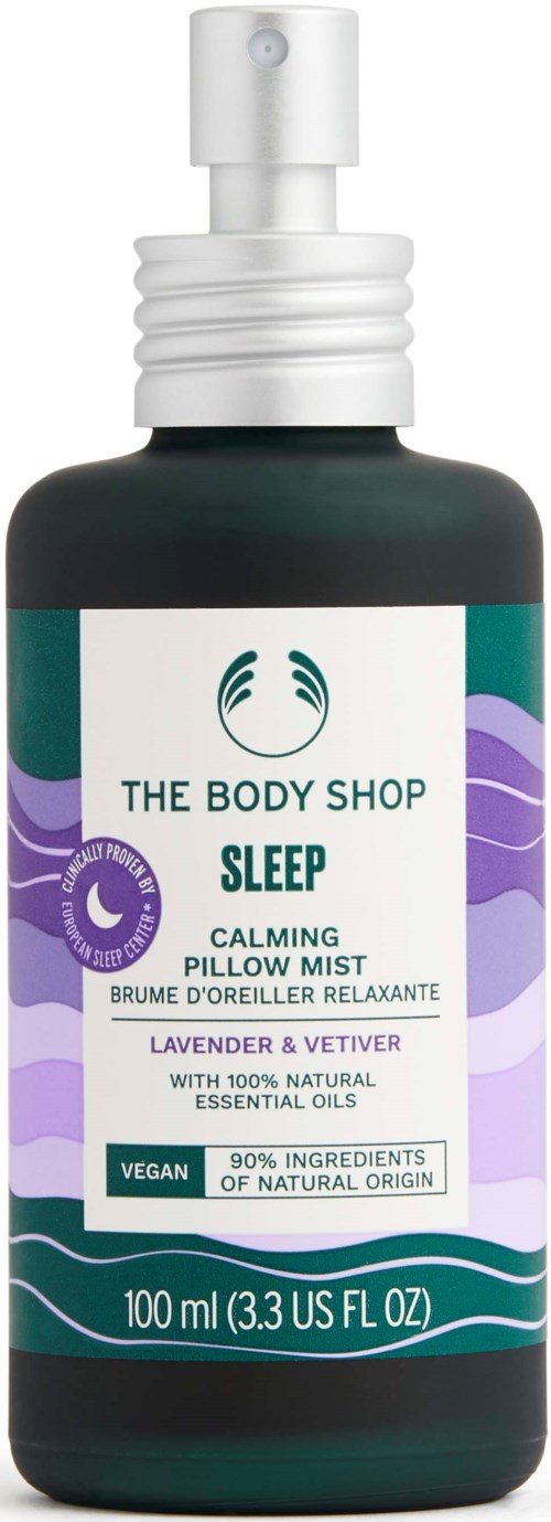 Eine schwarze Sprühflasche mit Sleep Calming Pillow Mist von The Body Shop, mit lila, grünem und weißem Etikett.