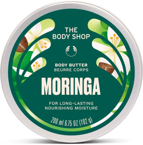 En rund lock av fat med grönt och vitt blomsterdesign, visar The Body Shop Moringa kroppssmörj etikett.