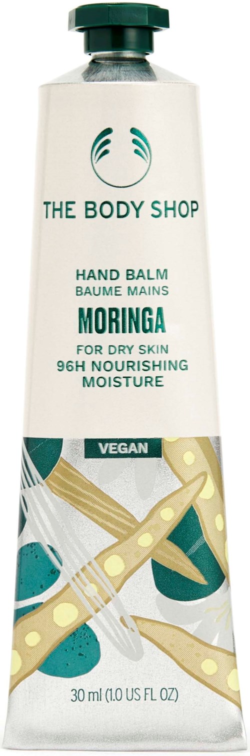 A tube of The Body Shop Moringa hand balm with a green cap, featuring text about vegan, nourishing, and moisturizing qualities.