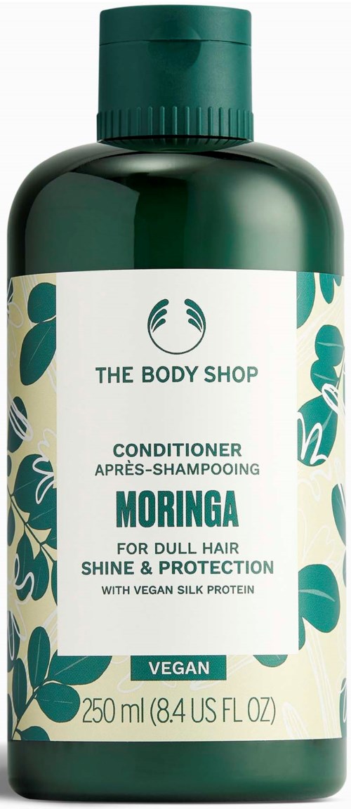 Grønn flaske av The Body Shop Moringa balsam med hvit etikett og grønne blader.