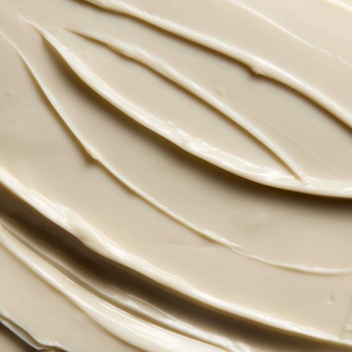 Närbild av krämfärgade swirls på en slät yta.