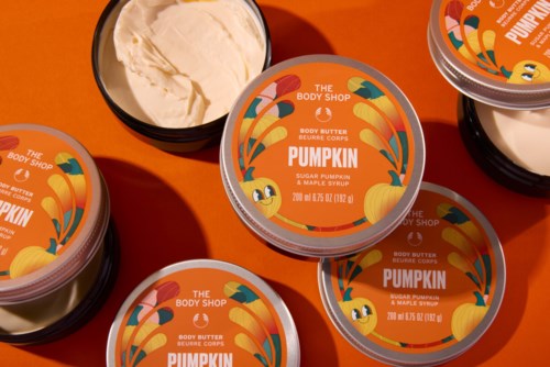Labeled body butter containers with pumpkin illustration, showing product name and scent on bright orange background.
