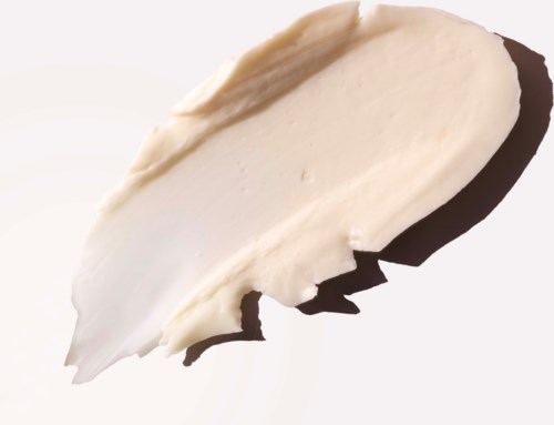 Creamy white skincare product spread on a surface with a smooth texture.