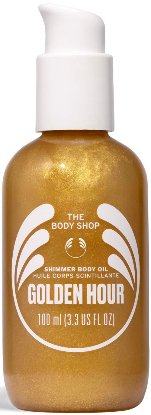 En guldfärgad flaska med vit pump, märkt Golden Hour shimmer body oil från The Body Shop.