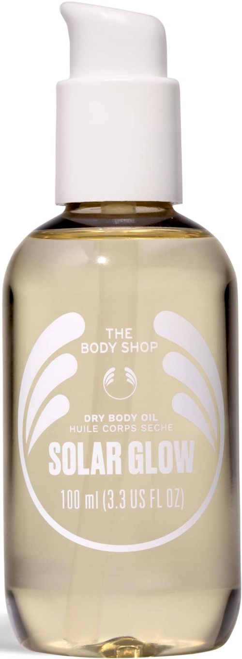 En klar flaska med vit etikett och pump, innehållande torr kroppsolja kallad Solar Glow från The Body Shop.