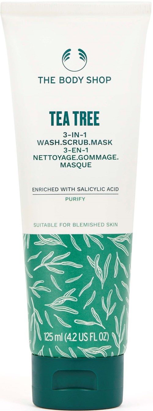 En hvit og grønn tube av The Body Shop Tea Tree 3-i-1 vask, skrubb, maske for uren hud med tea tree-blader.