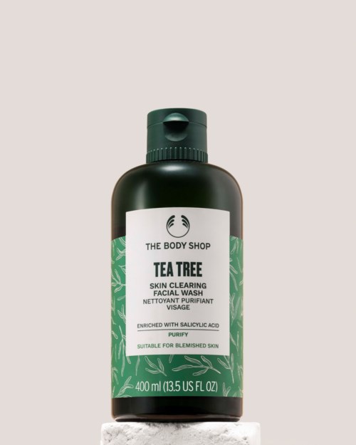 A black bottle of The Body Shop Tea Tree Face Wash with green label and cap, containing 400ml.
