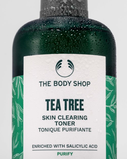 The Body Shop Tea Tree ihoa puhdistava kasvovesipullo mustalla korkilla, valkoinen etiketti ja vihreä lehtiopaste.