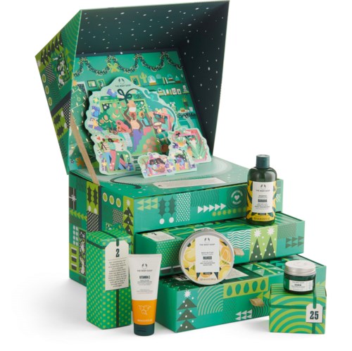 Ett jultema-presentset innehåller hudvårdsprodukter, festliga dekorationer och färgglad förpackning med gröna och blå mönster.