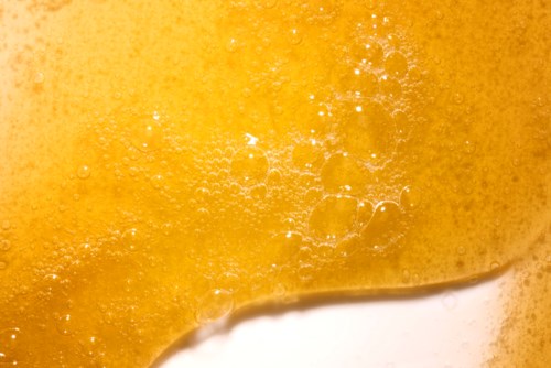 Close-up of frothy beer showing bubbles and golden foam.