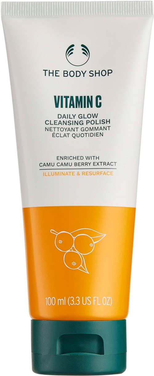 En tub med The Body Shop Vitamin C rengöringspeeling med orange och vit design, med text och ett bladillustration.
