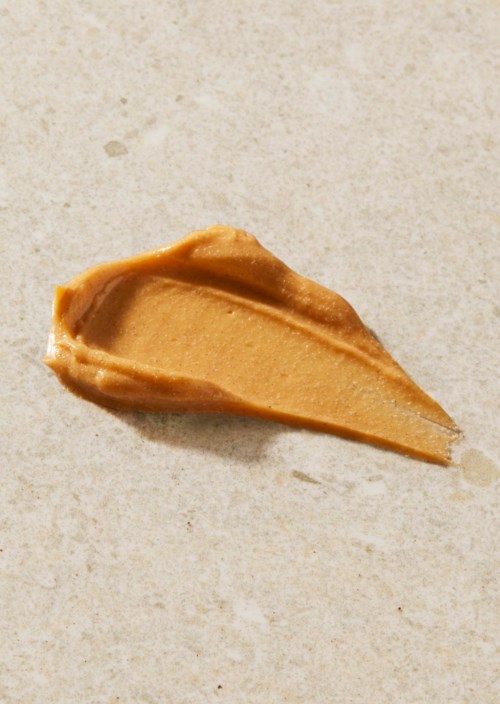 Ein Löffel Erdnussbutter auf einer hellen Oberfläche.