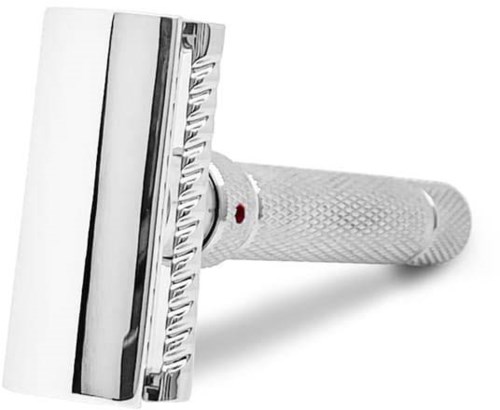 A white safety razor with a textured handle and a red dot, laying flat on a white surface.