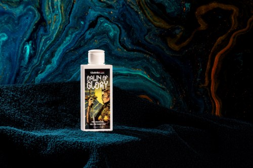 A small bottle with a colorful label stands on a textured surface against a dark, swirling background of blue and orange.