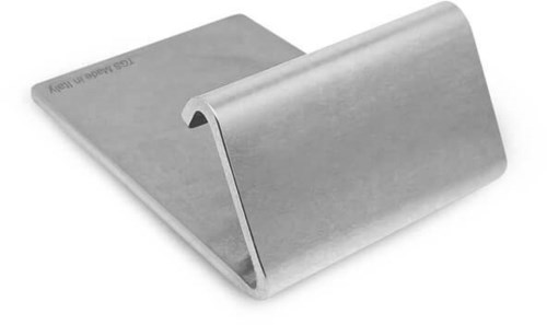 A metallic object with a curved shape, resembling a slide or a display stand, with a smooth surface.