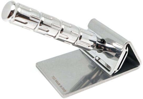 A shiny metal object, possibly a tool or part, is on a flat stand with a sloped support.