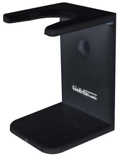 A black device with a stand, a top hook, a hole, and the text "Good the class smile" on it.