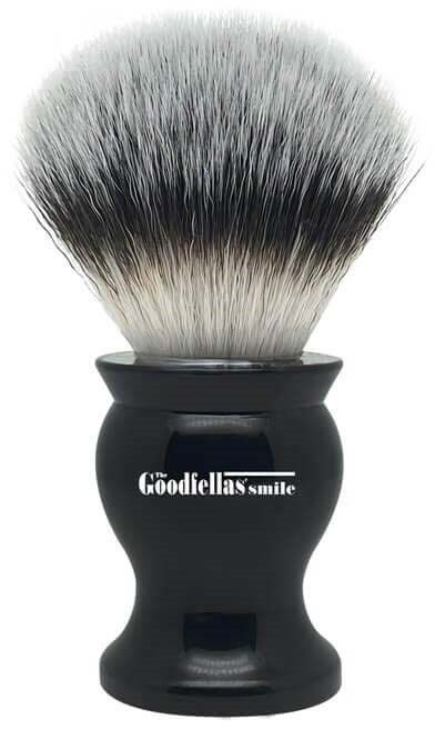 A shaving brush with black handle and white-to-black bristles, labeled 'The Goodfellas Smile' on the handle.
