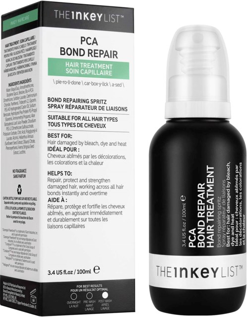 Een zwart-witte fles met pomp naast een doos. Het label zegt "PCA Bond Repair" voor haarbehandeling.