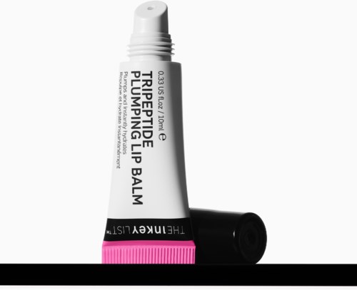 Lippenbalsem in een witte tube met zwarte en roze accenten, gemarkeerd als triple actie lipverzorgingsbalsem.