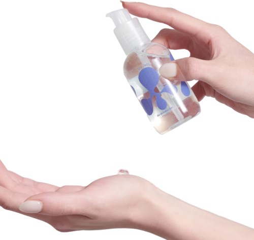 A person holds a clear hand sanitizer bottle with blue circles, dispensing sanitizer onto another hand.