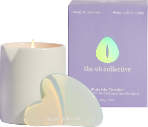 A white candle with a flame, a heart-shaped wax melt, and a purple box. The box has a logo and text.