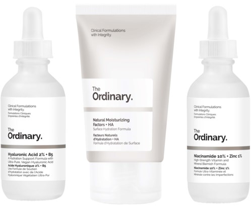 Two small bottles and a tube of skincare products with simple labels from The Ordinary brand.
