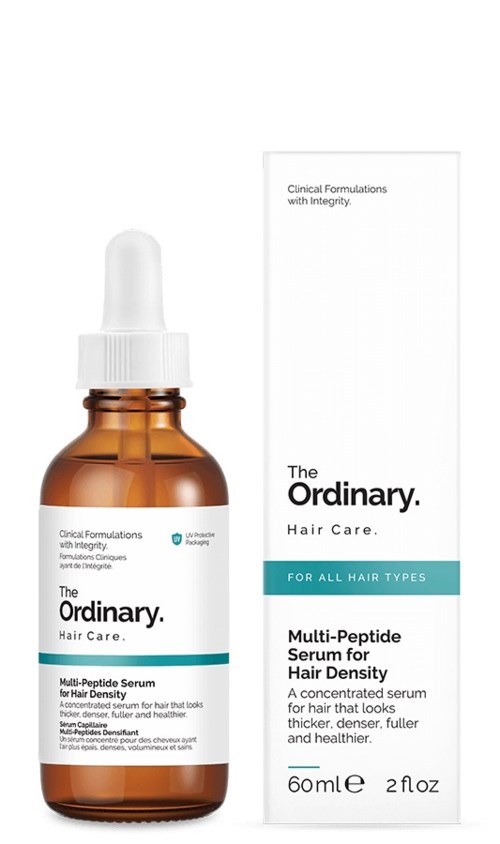Een bruin glazen fles met pipet naast een doos, allebei gelabeld voor The Ordinary haarserum voor dik haar.