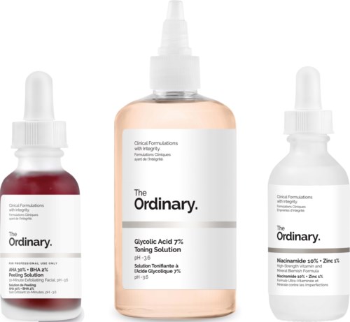 Drie flessen huidverzorgingsproducten, elk met een witte pipetdop en wit label, met merknaam 'The Ordinary'.