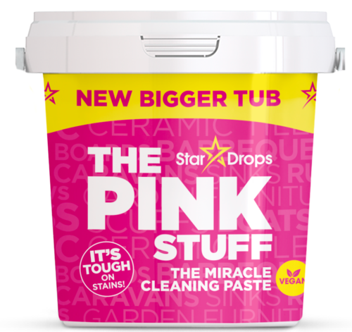 A container of pink cleaning paste called 'The Pink Stuff' with a yellow label highlighting a new bigger size and vegan info.