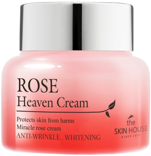 Een roze pot met een zilveren deksel, met label 'Rose Heaven Cream' voor huidbescherming en whitening, door The Skin House.