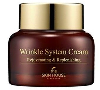 Een potje met Wrinkle System Cream label van The Skin House, gouden deksel, donkerbruine container, voor huidverzorging.