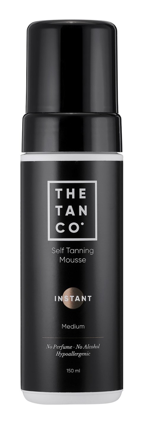 Black spray bottle of self-tanning mousse with white and gray text, labeled "THE TAN CO. INSTANT Medium."