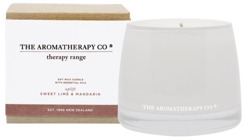 A white candle with a box showing the scent of lime and mandarin, from The Aromatherapy Co, with a textured lid.