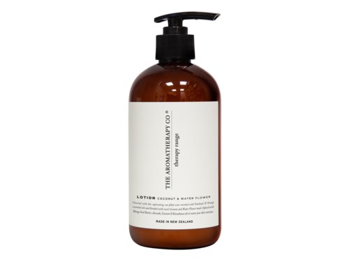 A brown bottle with a pump, containing lotion with a white label about coconut and water flowers.