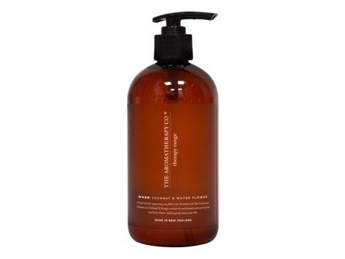 A brown bottle with a pump, labeled as a body wash with coconut and water flower scent, made in New Zealand.