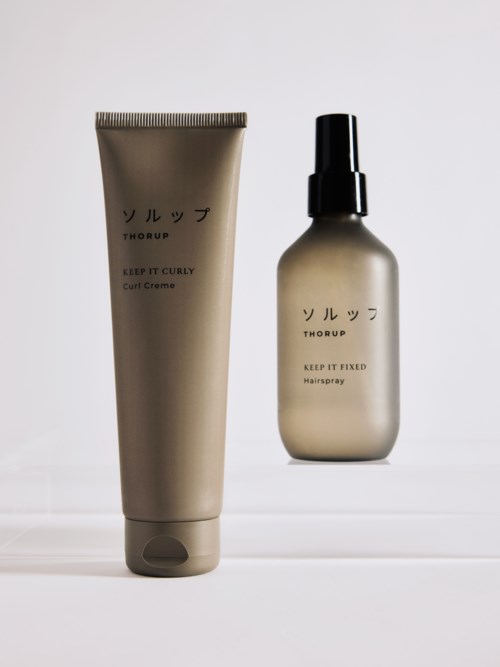 Two hair care products, a tube and a spray bottle, with Japanese writing on a plain white background.