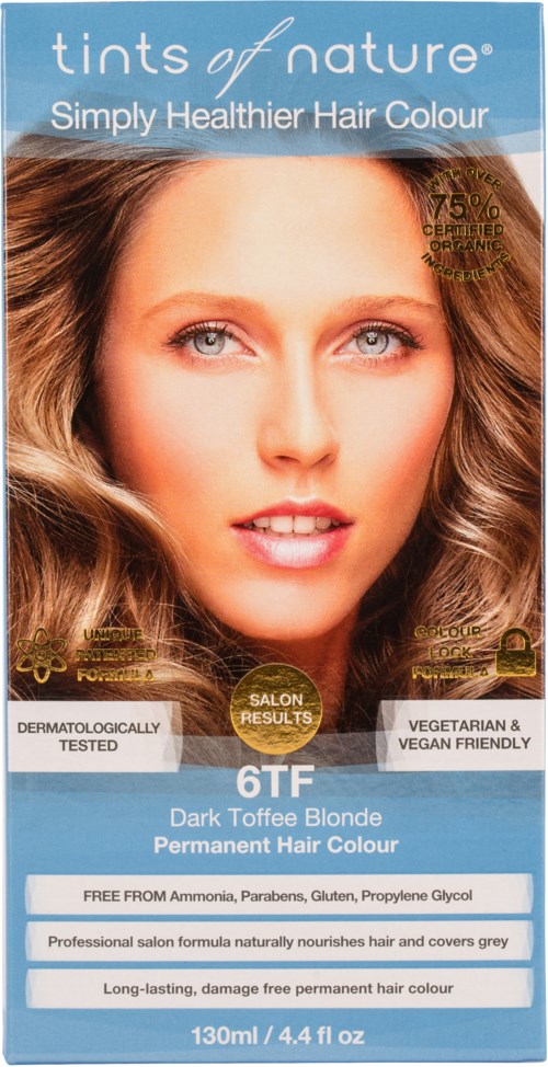 A woman with long, wavy blonde hair and blue eyes, promoting a hair dye product. Text highlights healthy, vegan formula.