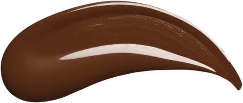 Braune Creme, gestrichen mit einem Pinsel, auf schwarzem Hintergrund.