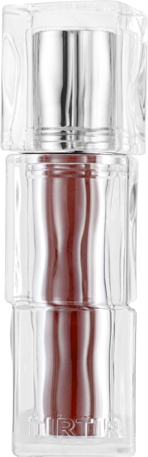 A transparent perfume bottle with a silver cap, containing reddish liquid and a stylized label at the bottom.