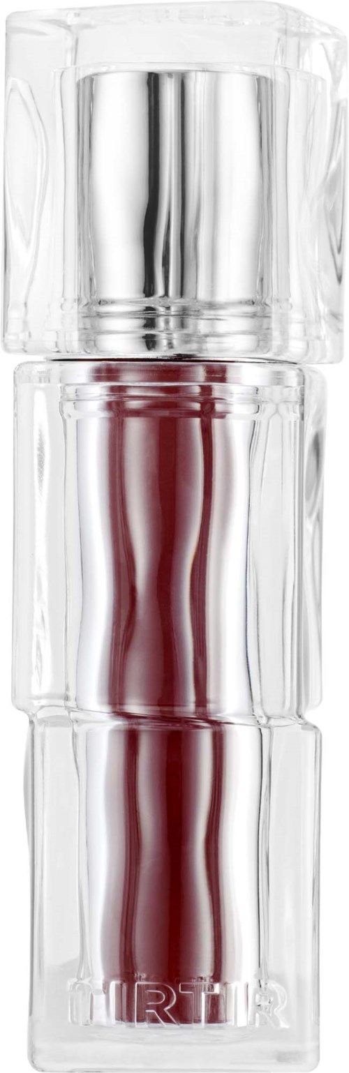 A tall, clear glass container with a red and silver makeup or perfume item inside. It has a shiny silver cap.