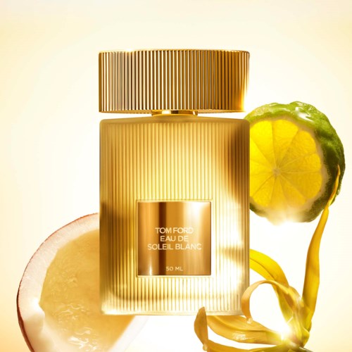 Eine goldene Parfüfflasche mit Zitrone und Limette daneben, glänzendes und elegantes Design.