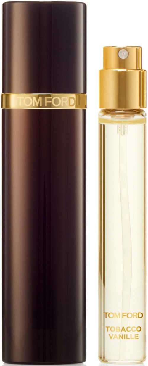 A perfume bottle with a gold cap and label, next to a tall, dark, cylindrical container.