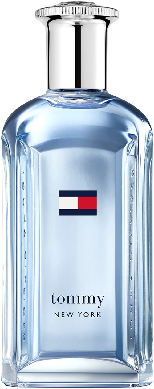 A clear glass bottle with a silver cap, labeled 'tommy NEW YORK', contains a bluish liquid, likely perfume.