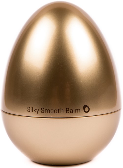 Ein goldener, eiförmiger Behälter mit der Aufschrift 'Silky Smooth Balm'.