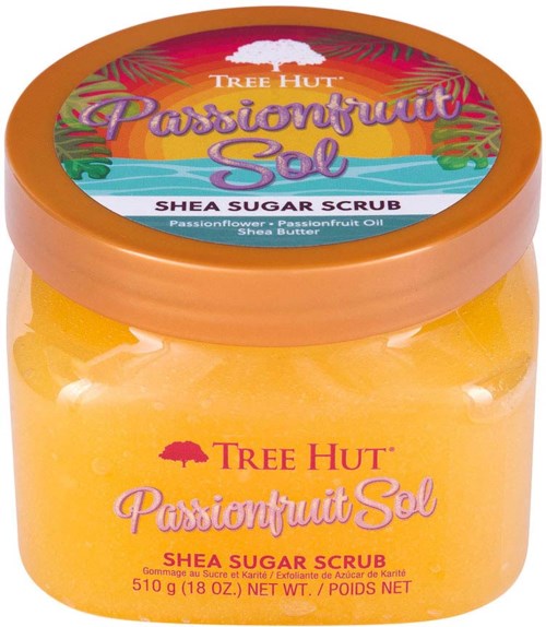 Ein Glas mit Tree Hut Passionfruit Salt Shea Sugar Scrub mit hellen Etiketten und orangefarbener Schaum im Inneren.