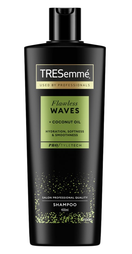 Black shampoo bottle with green and yellow label, containing Tresemmé Flawless Waves shampoo with coconut oil.