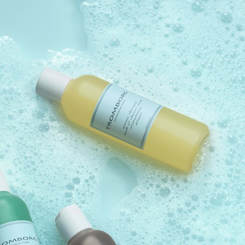 Eine gelbe Flasche mit Hautpflegeprodukt im Seifenwasser.